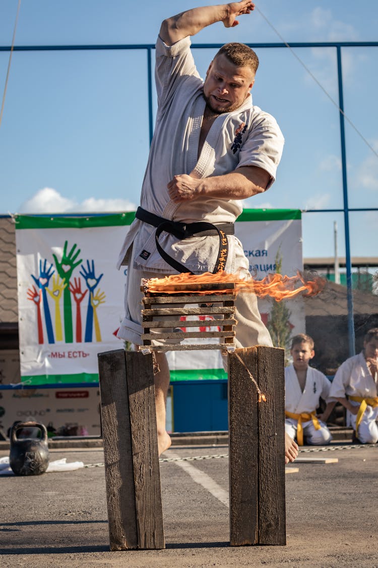 Man Breaking Burning Bricks Outdoors