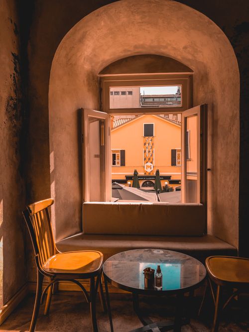 Free Warm-toned room with open window view, chairs, and table creating a cozy ambiance. Stock Photo