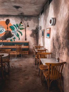 Warm, inviting café featuring rustic furniture and vibrant wall art. Ideal urban retreat setting.