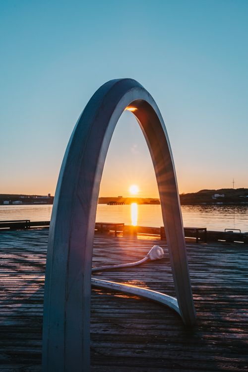 Free A captivating sunset through a modern metal arch on a serene pier. Stock Photo