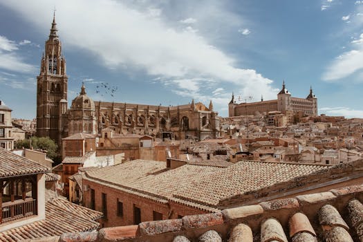 Panoramic view of Toledo with the historic cathedral and cityscape under a blue sky.