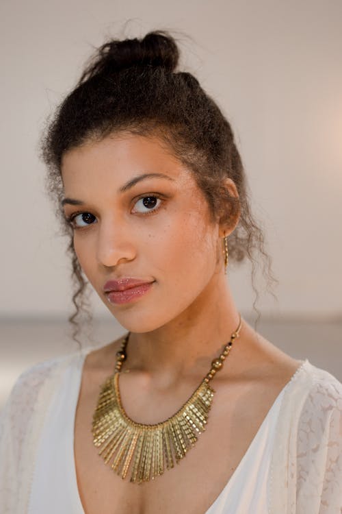 Portrait of a Woman with Curly Hair Wearing a Gold Necklace