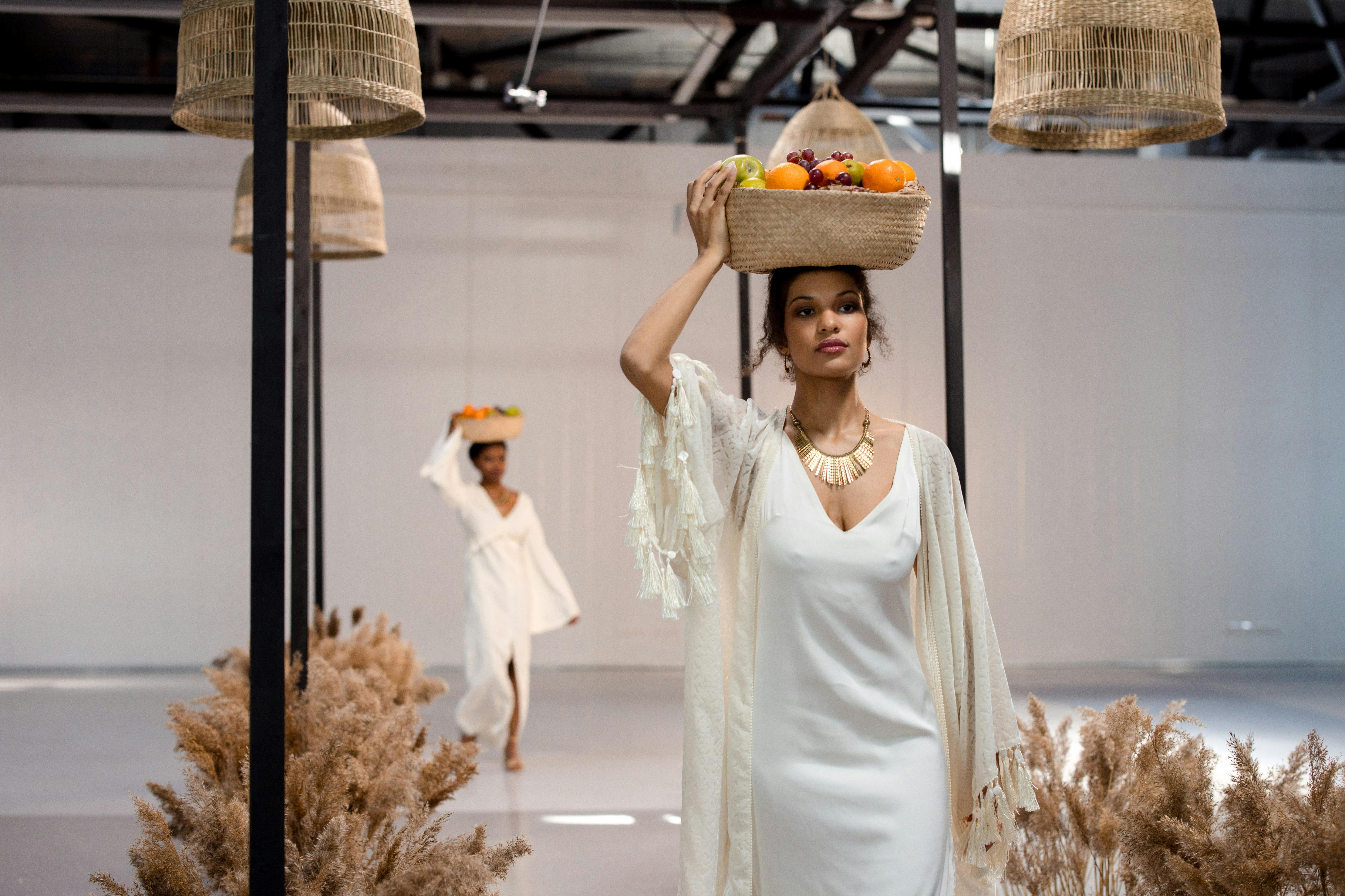 woman carrying basket of fruits on head