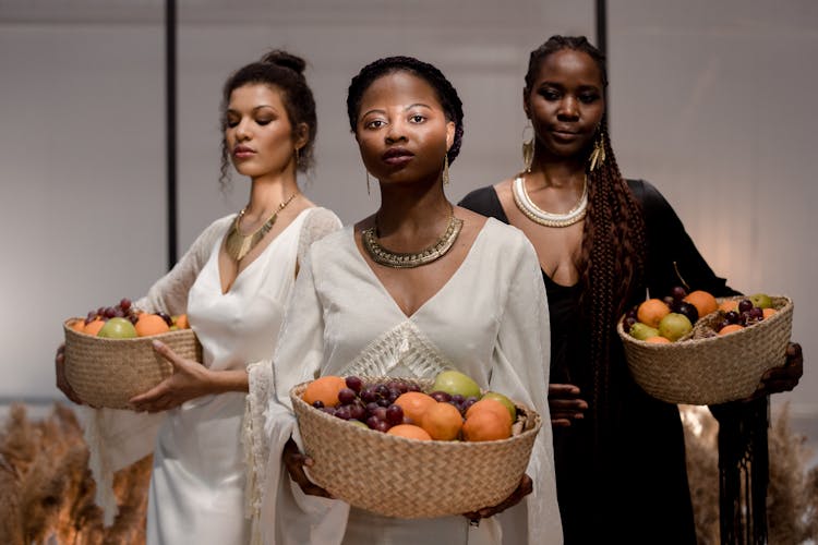 People Carrying A Basket With Fruits