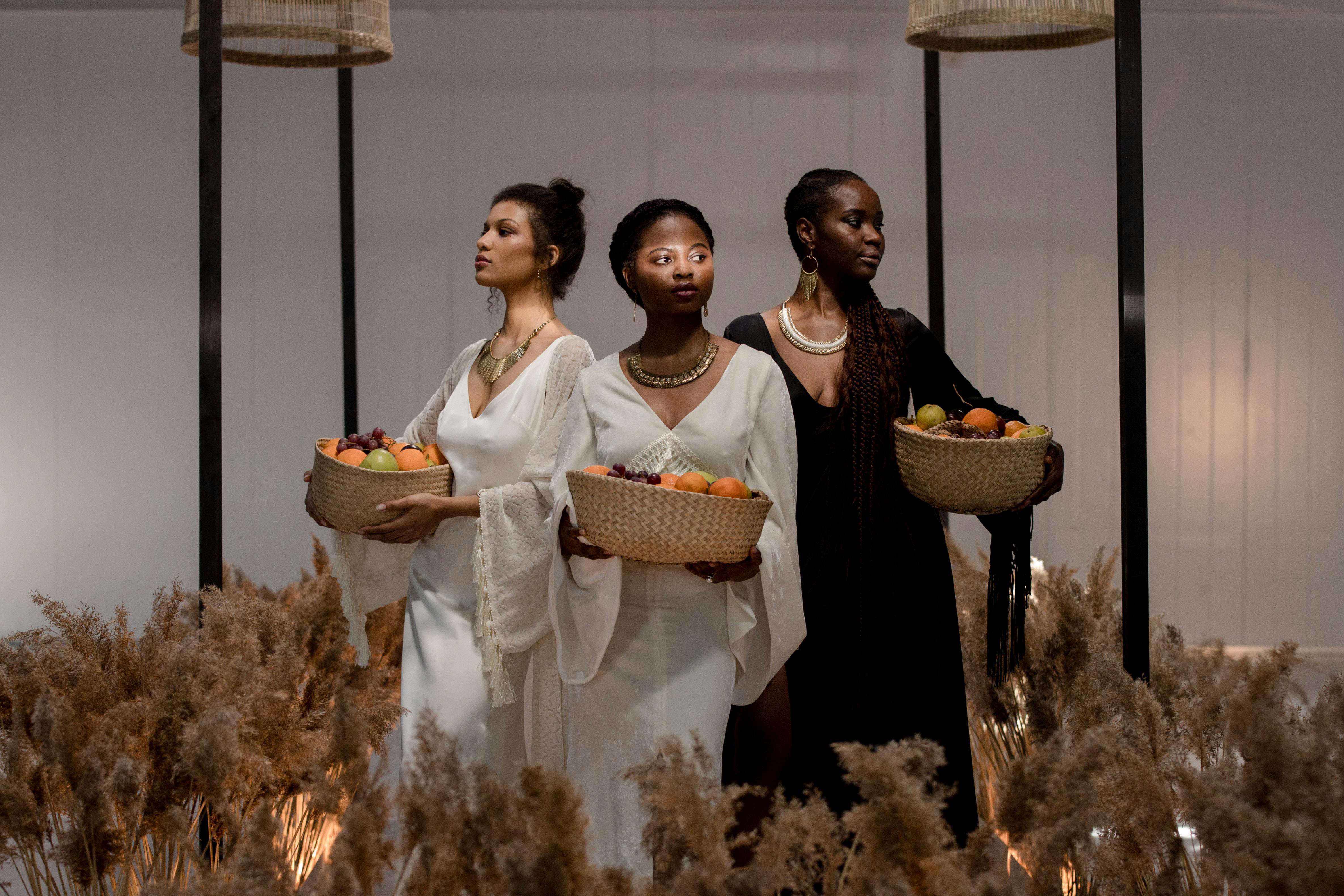 models carrying woven baskets with assorted fruits