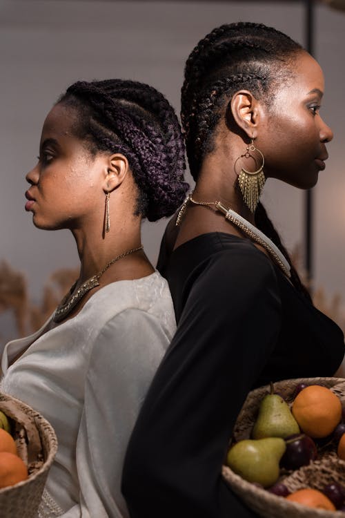 Women With Braided Hair Standing Back to Back 