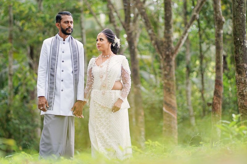 Sri Lankan couple in traditional wedding attire in serene forest