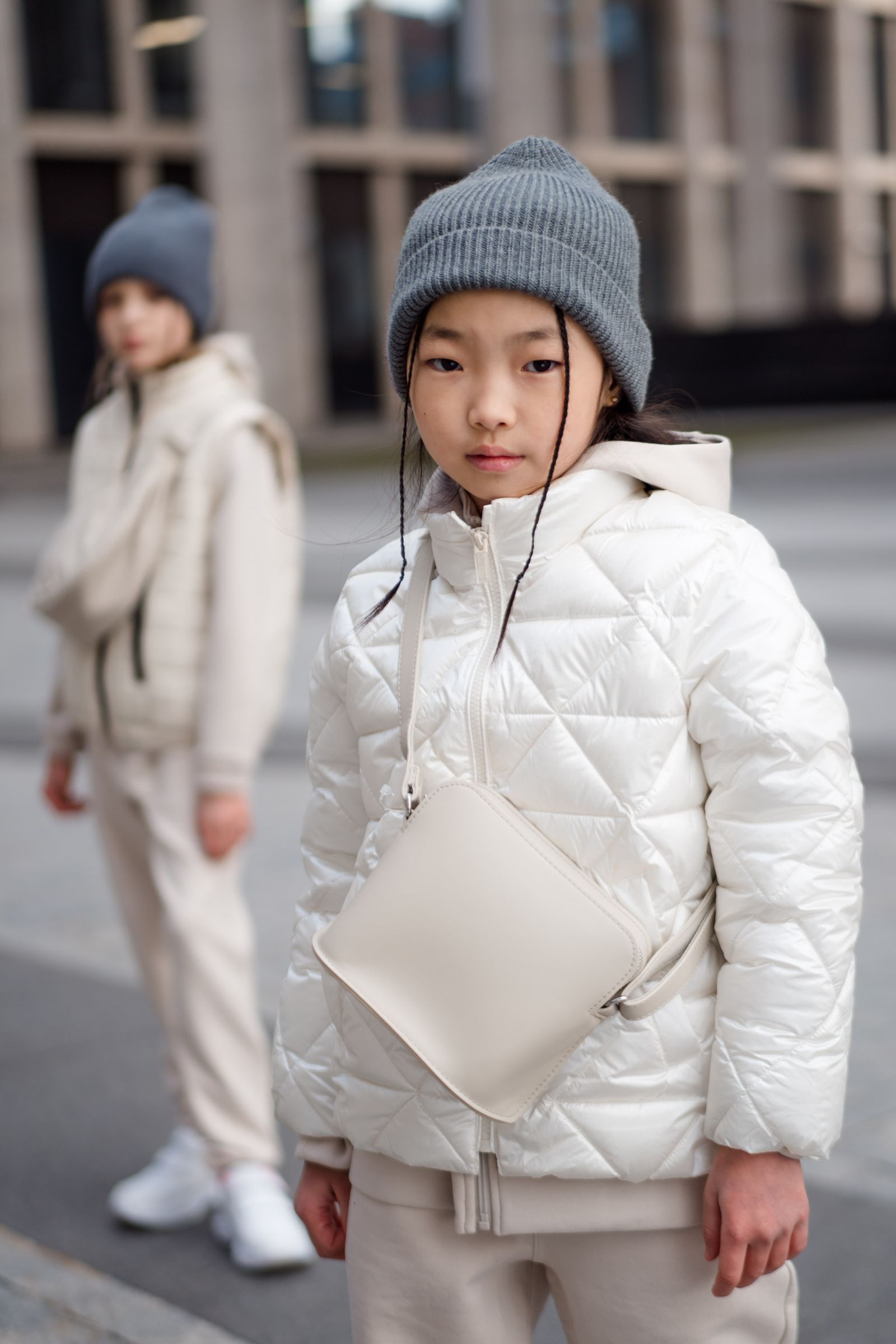 Children wearing soft white outerwear and knit hats outdoors