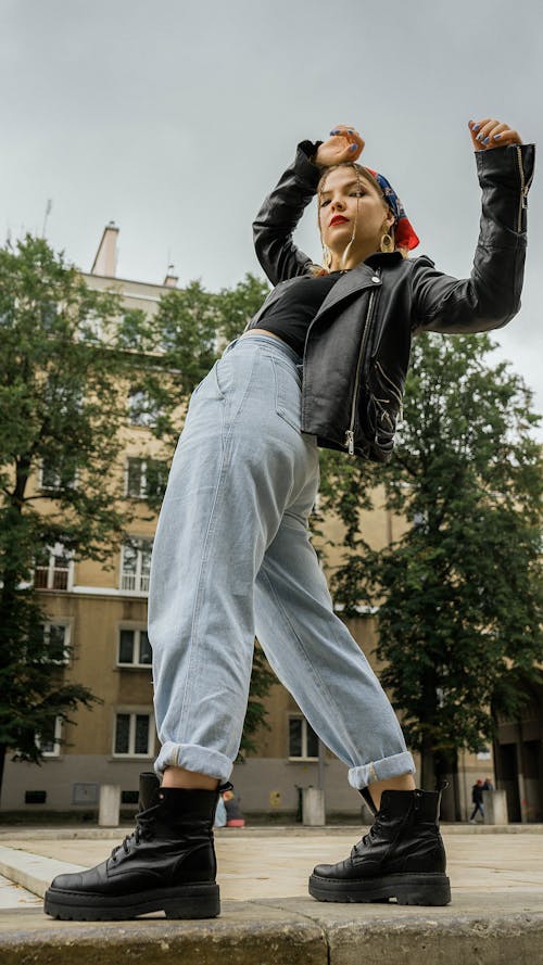 Low-Angle Shot of a Woman Wearing a Black Leather Jacket and Denim Jeans