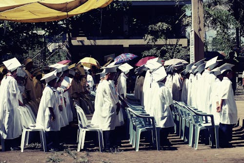 무료 낮에 졸업식에서 흰색 학원 가운을 입은 아이들 스톡 사진
