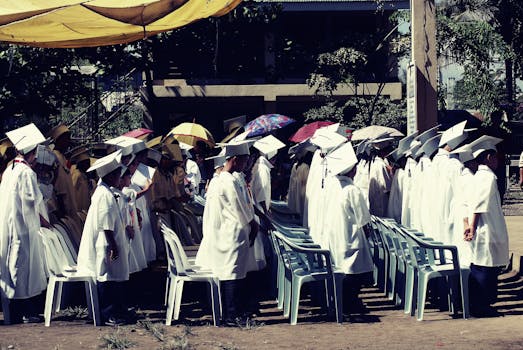 Group of children in academic gowns celebrating graduation outdoors.
