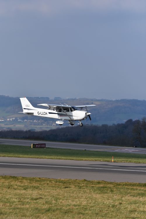 Free A small aircraft lifts off the runway, soaring over scenic landscape on a clear day. Stock Photo