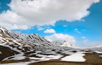 白雪覆盖的山脉令人惊叹，湛蓝的天空中云层散落