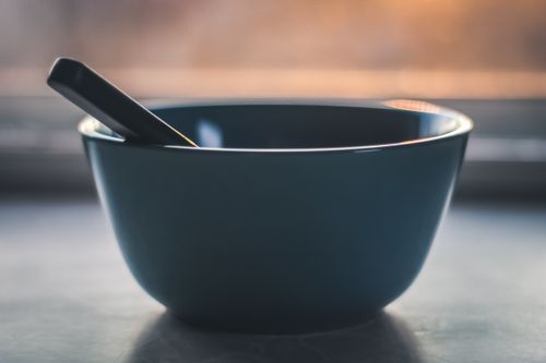 A minimalist empty bowl and spoon in soft light — photo by Steve A Johnson on Pexels
