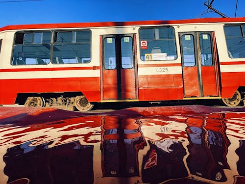 Red Tram Reflected in a Puddle