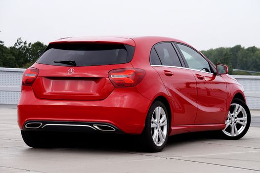 Sleek red Mercedes-Benz hatchback with modern design, viewed from the rear