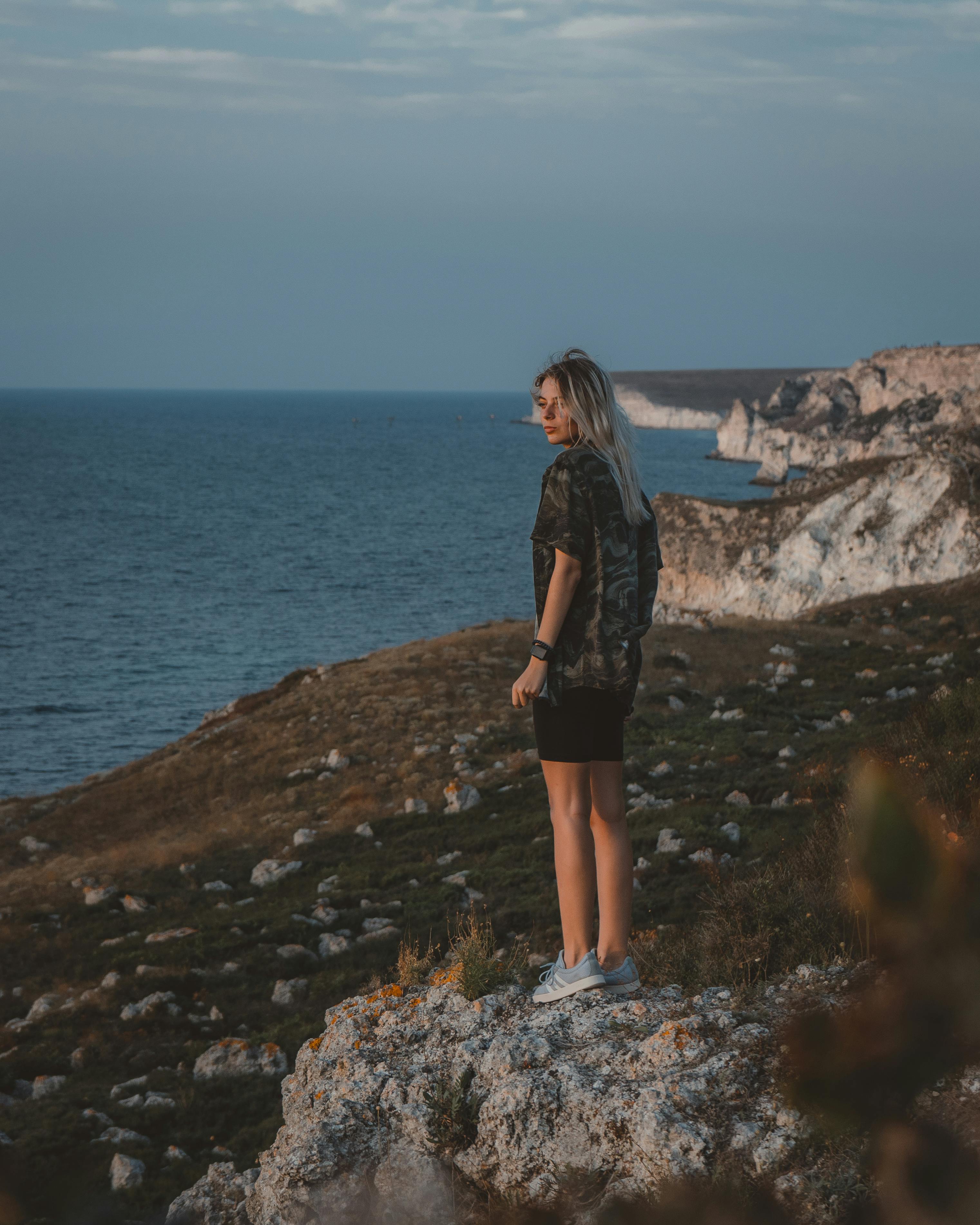 Man Standing on the Rock in Front of the Ocean · Free Stock Photo