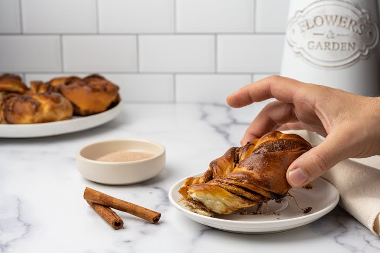 A Person Eating A Cinnamon Bread