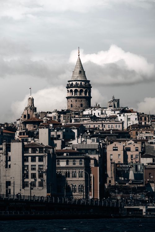 Free Vertical view of Galata Tower surrounded by Istanbul cityscape under a cloudy sky. Stock Photo