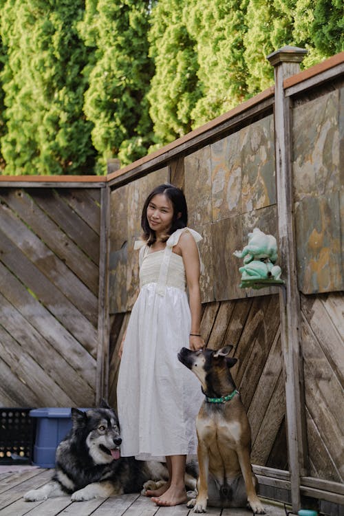 A Woman in White Dress Posing with Her Pet Dogs