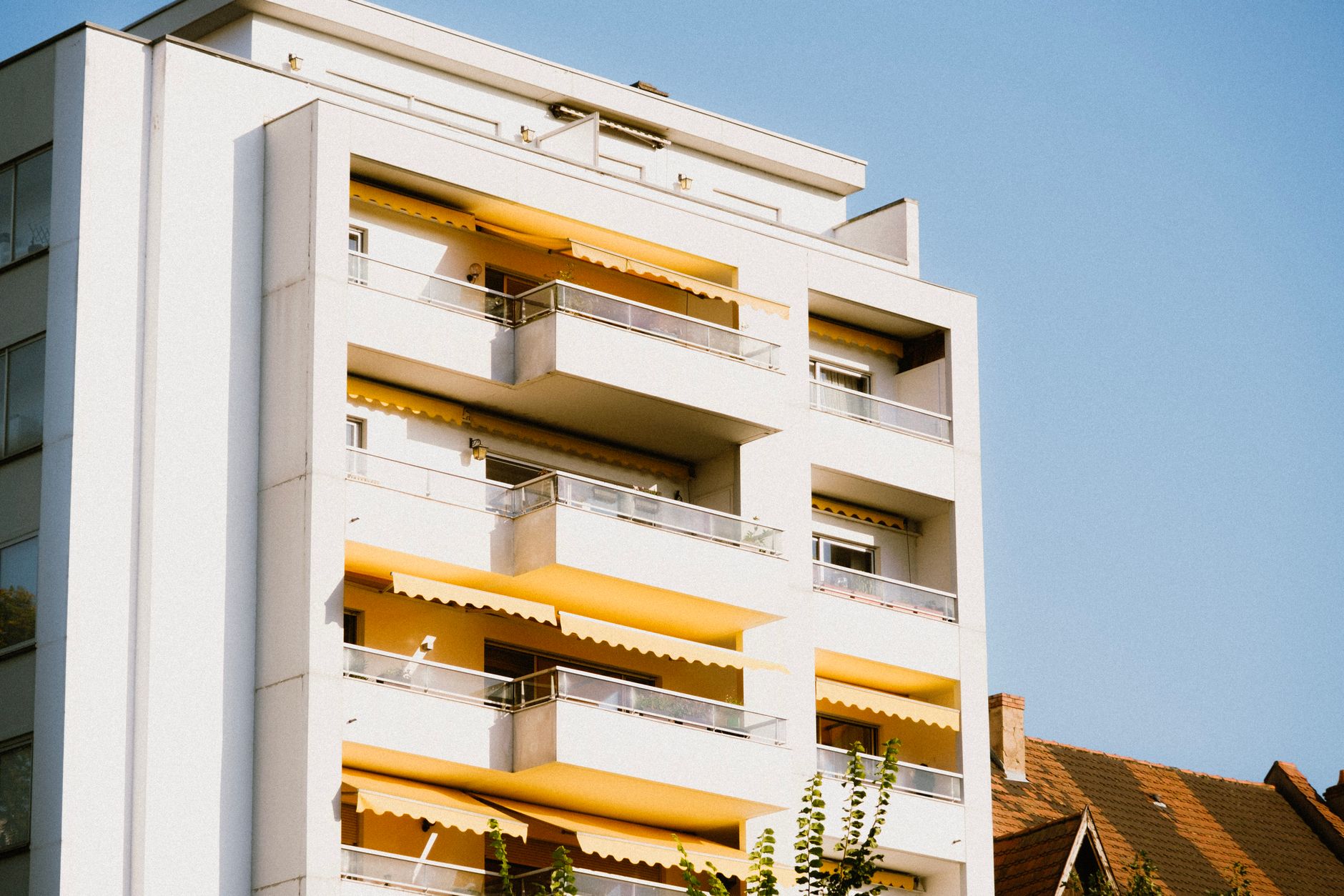 Appartementengebouw met gevel in fel zonlicht tegen een blauwe lucht