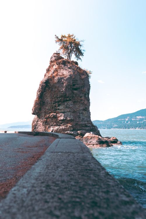 Free Stunning vertical view of Siwash Rock in Stanley Park, Vancouver, with ocean backdrop. Stock Photo