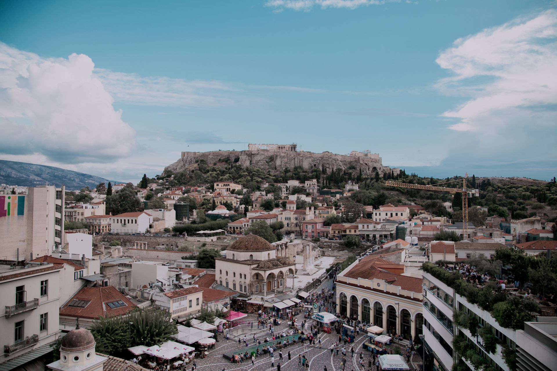Stunning aerial view of Athens cityscape with iconic Acropolis under blue skies.