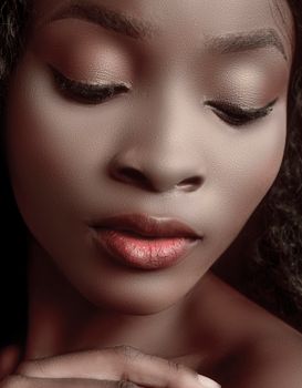 Close-up portrait of a serene black woman with natural beauty and calm expression.