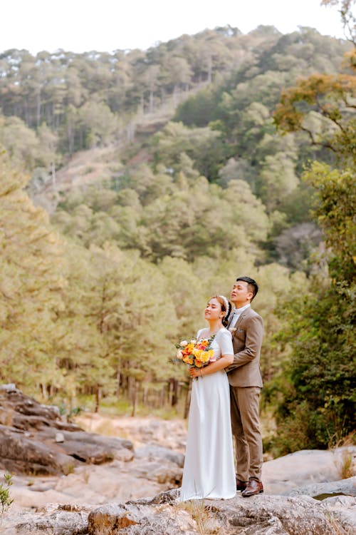 A Couple Standing on Brown Rock