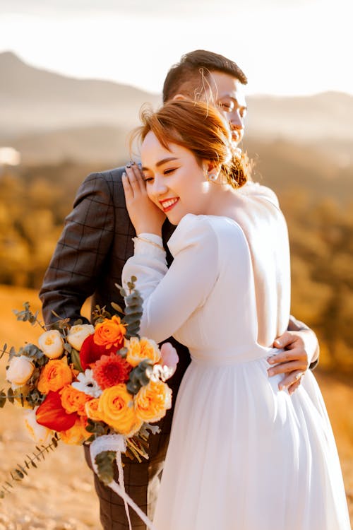 Free Man with Bouquet of Flowers Hugging a Woman  Stock Photo