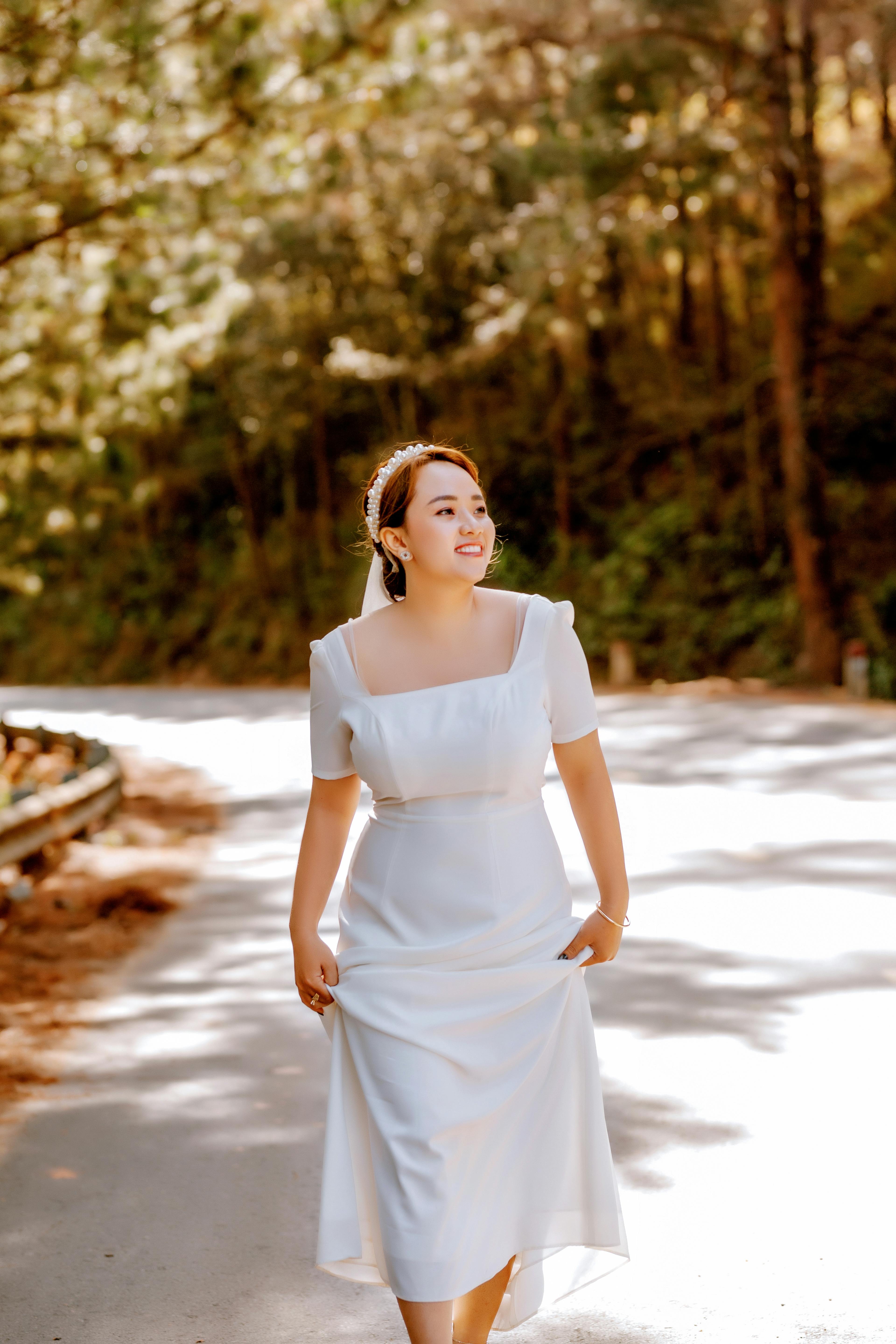 woman in white dress standing on brown dirt road