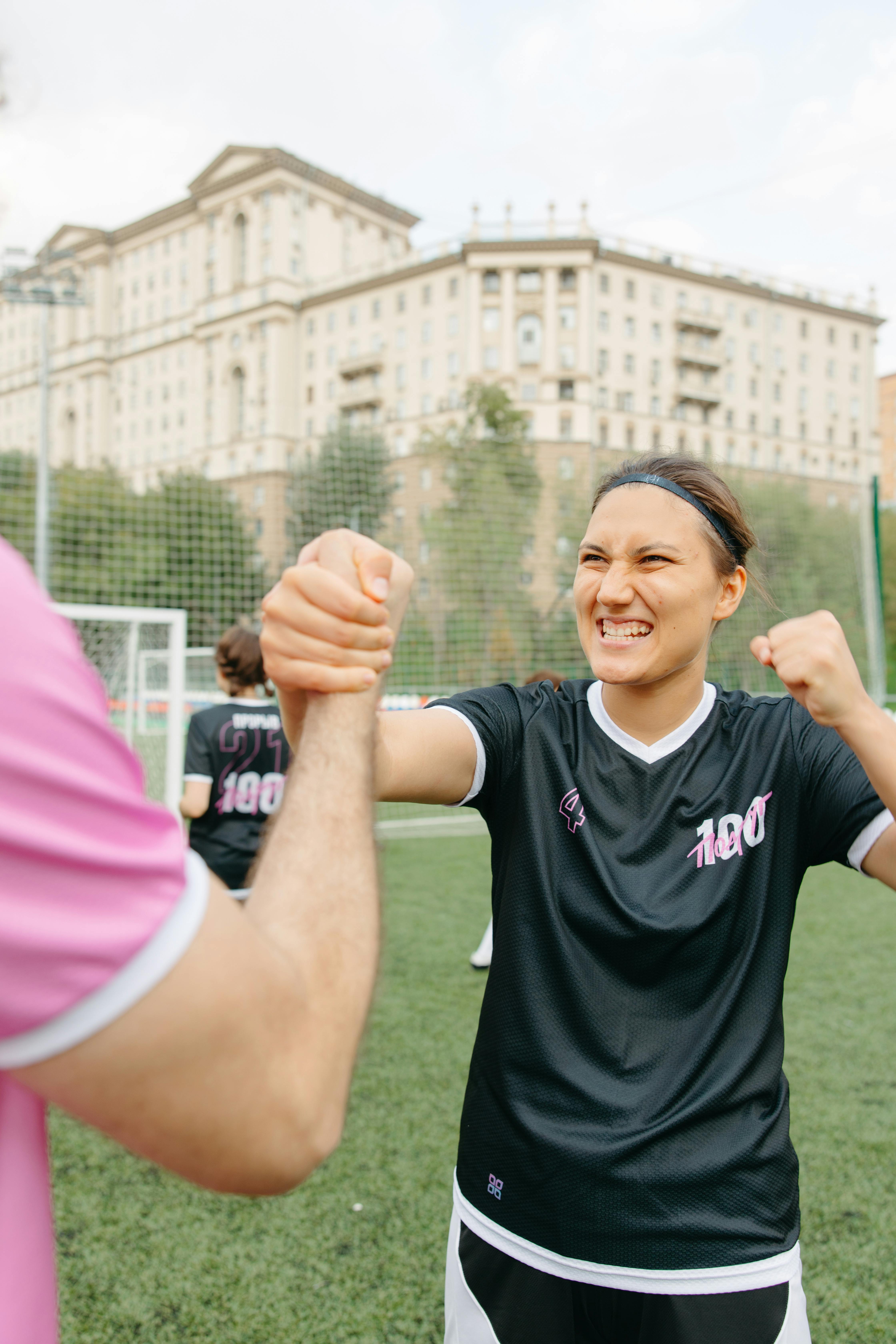 woman in black jersey shirt smiling with success