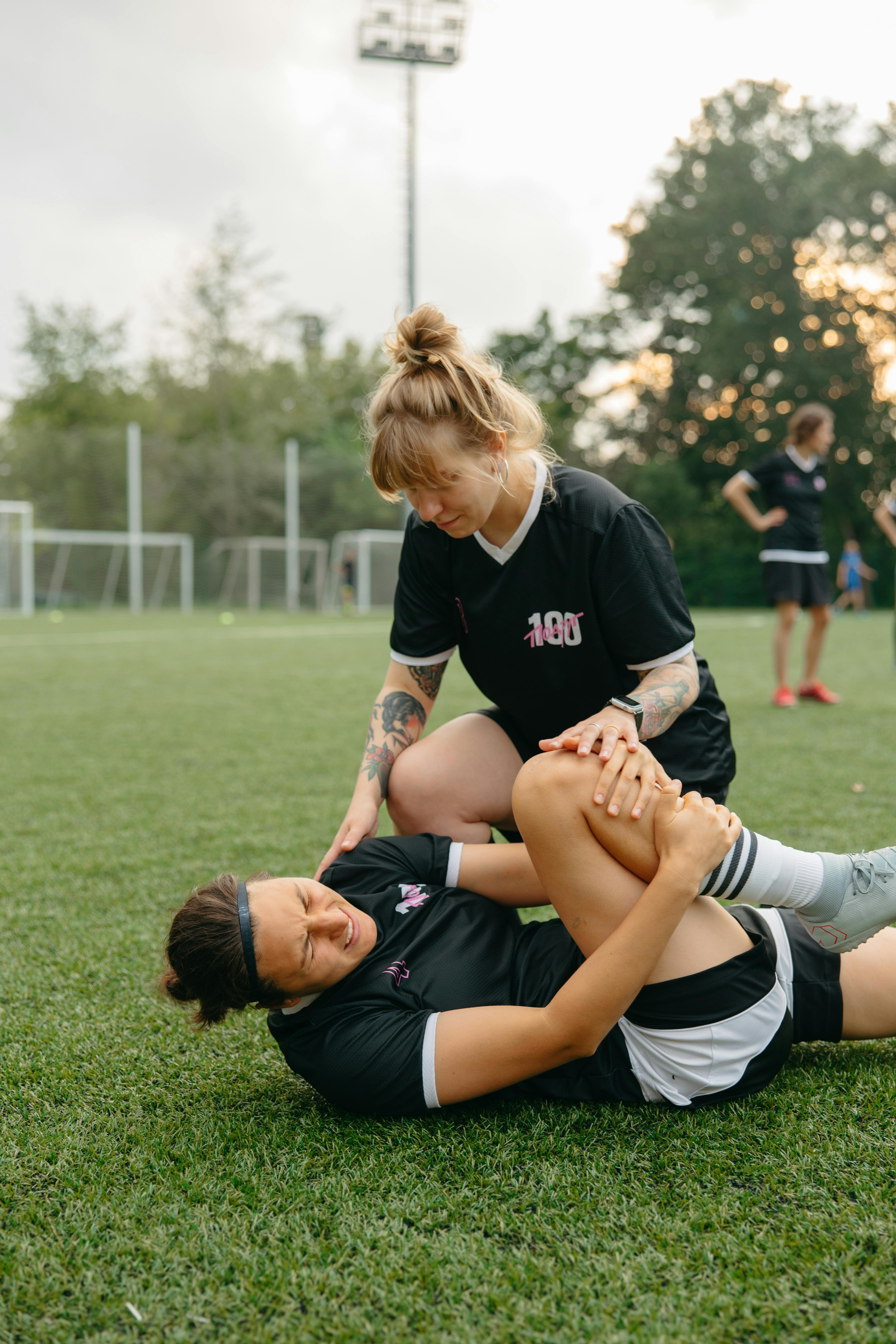 injured athlete lying on grass field