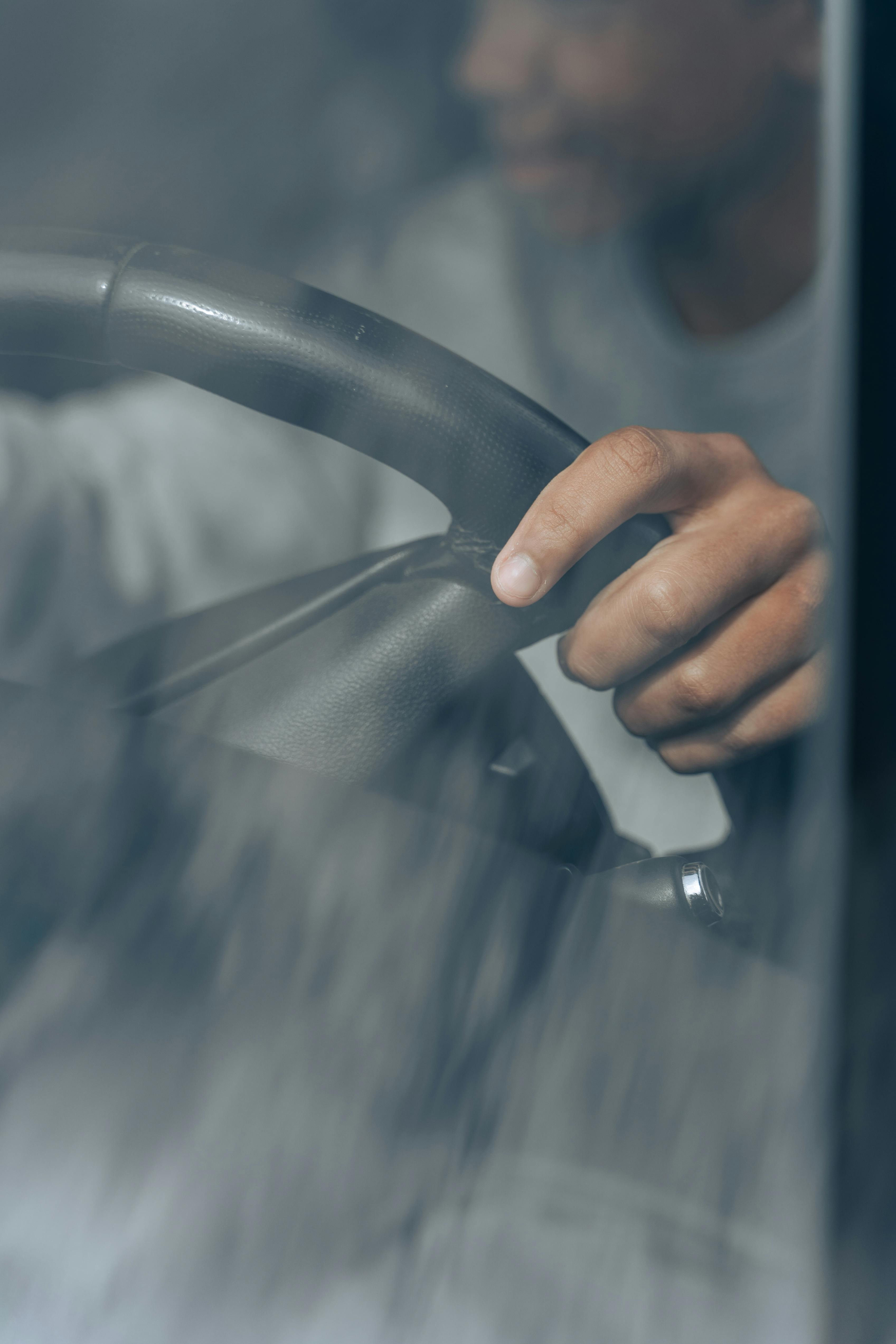 person holding gray car steering wheel