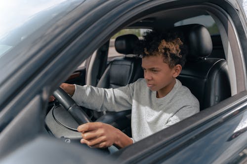 Boy in Gray Sweater Driving Car