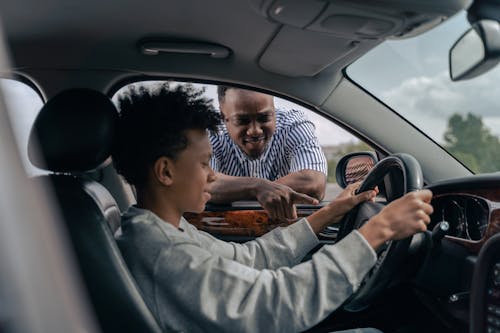 Free Man in Blue and White Striped Dress Shirt Sitting on Car Seat Stock Photo