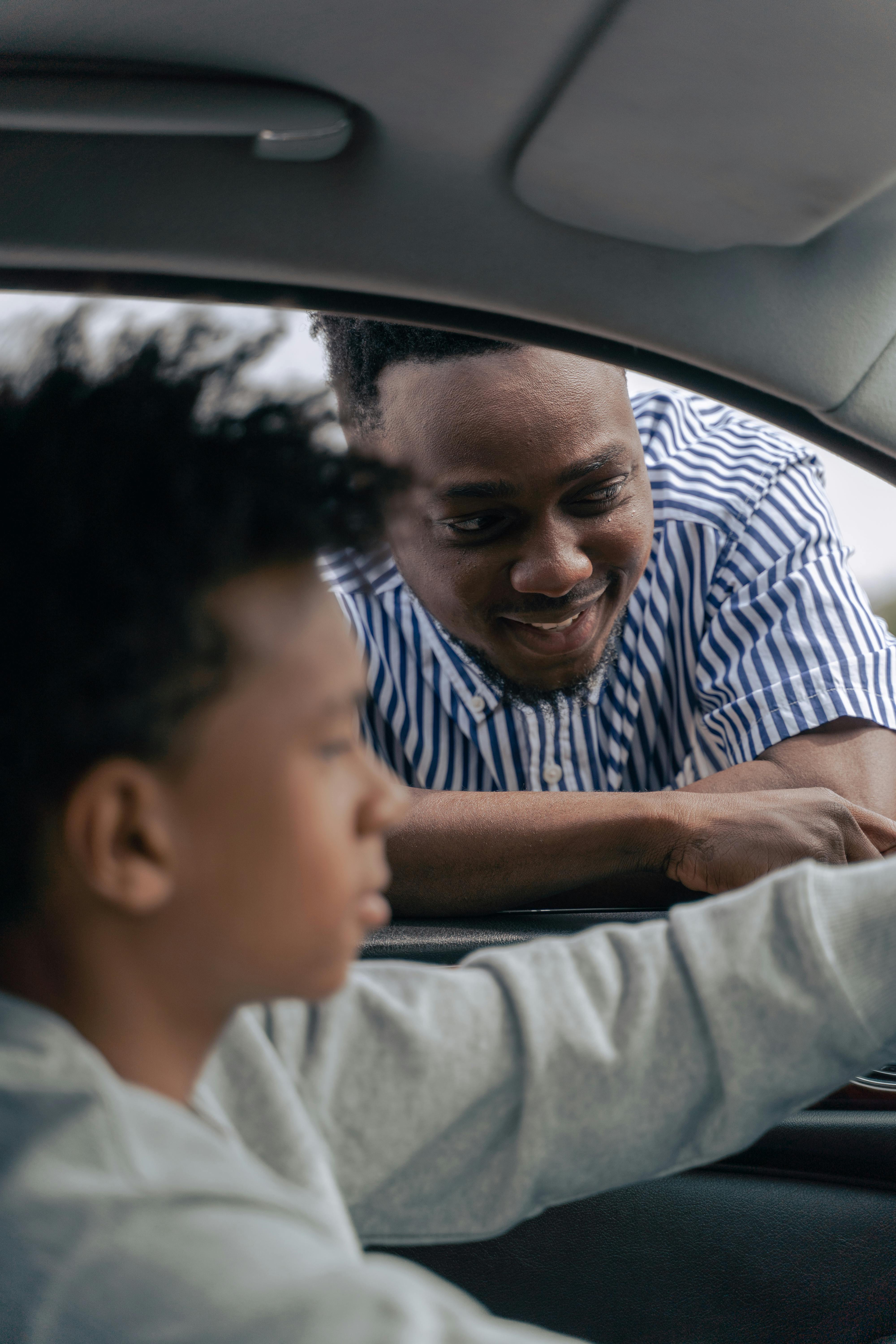 man in blue and white stripe shirt driving car