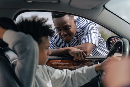 Free Man in White and Blue Striped Dress Shirt Sitting on Car Seat Stock Photo