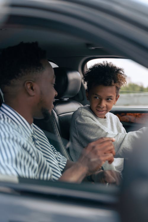 Man in White and Blue Striped Dress Shirt Driving Car