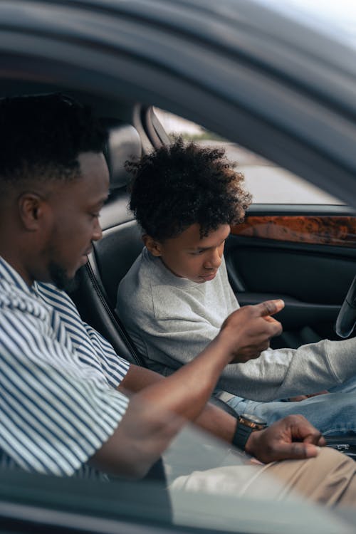 Man in Gray Dress Shirt Sitting on Car Seat