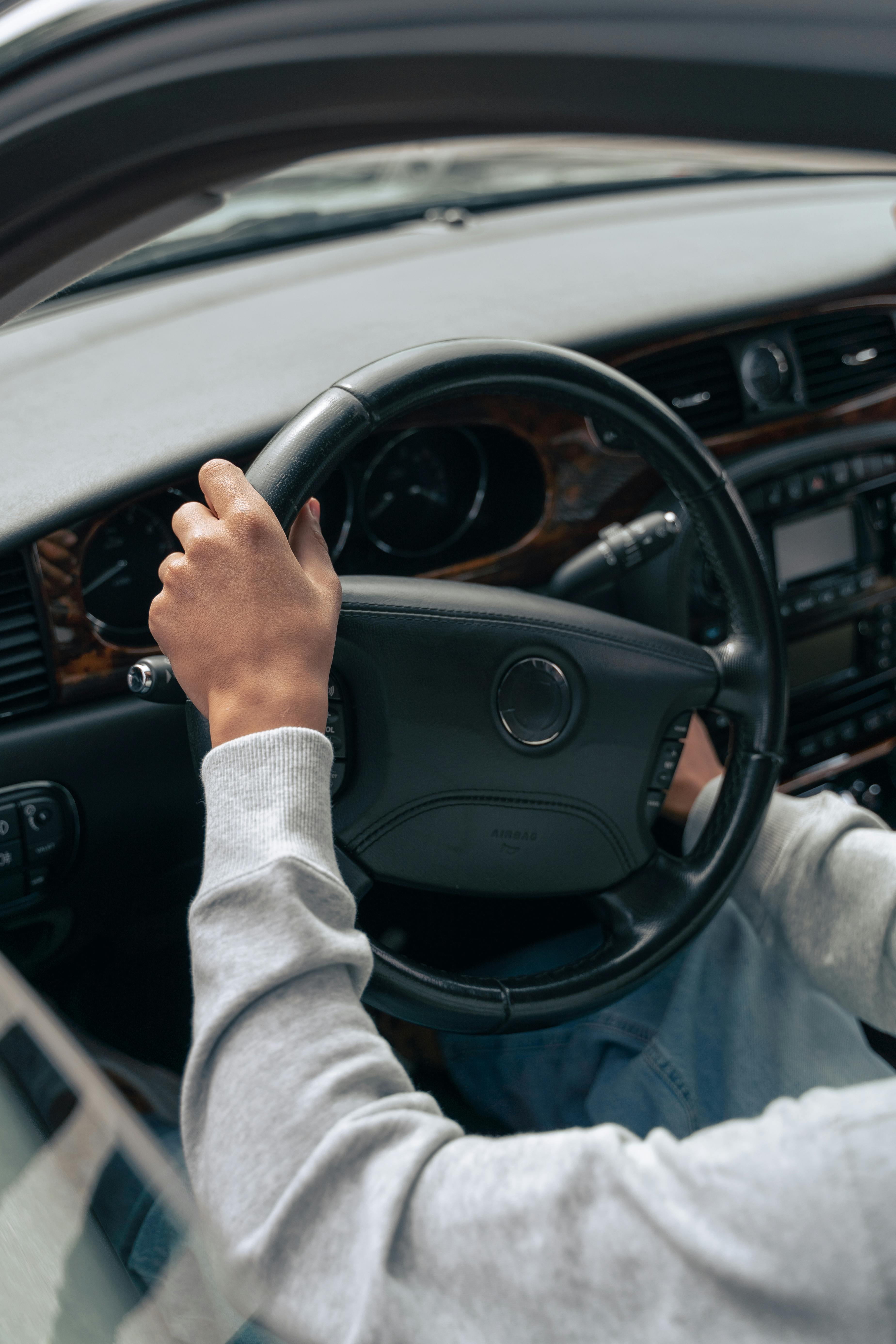 person in gray long sleeve shirt driving car