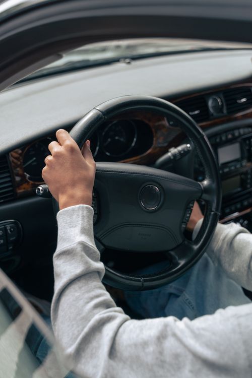 Free Hands on steering wheel inside a car, showcasing vehicle interior design. Stock Photo