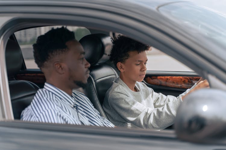 Man In White And Black Pinstripe Dress Shirt Driving Car