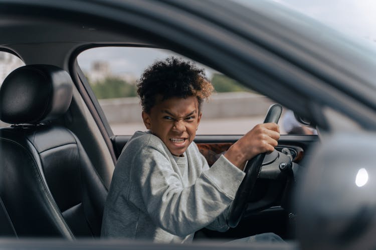 Man In Gray Hoodie Driving Car