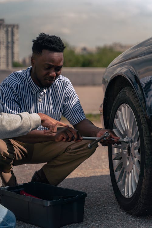 Man in Blue and White Striped Dress Shirt and Brown Pants Sitting on Wheel Chair