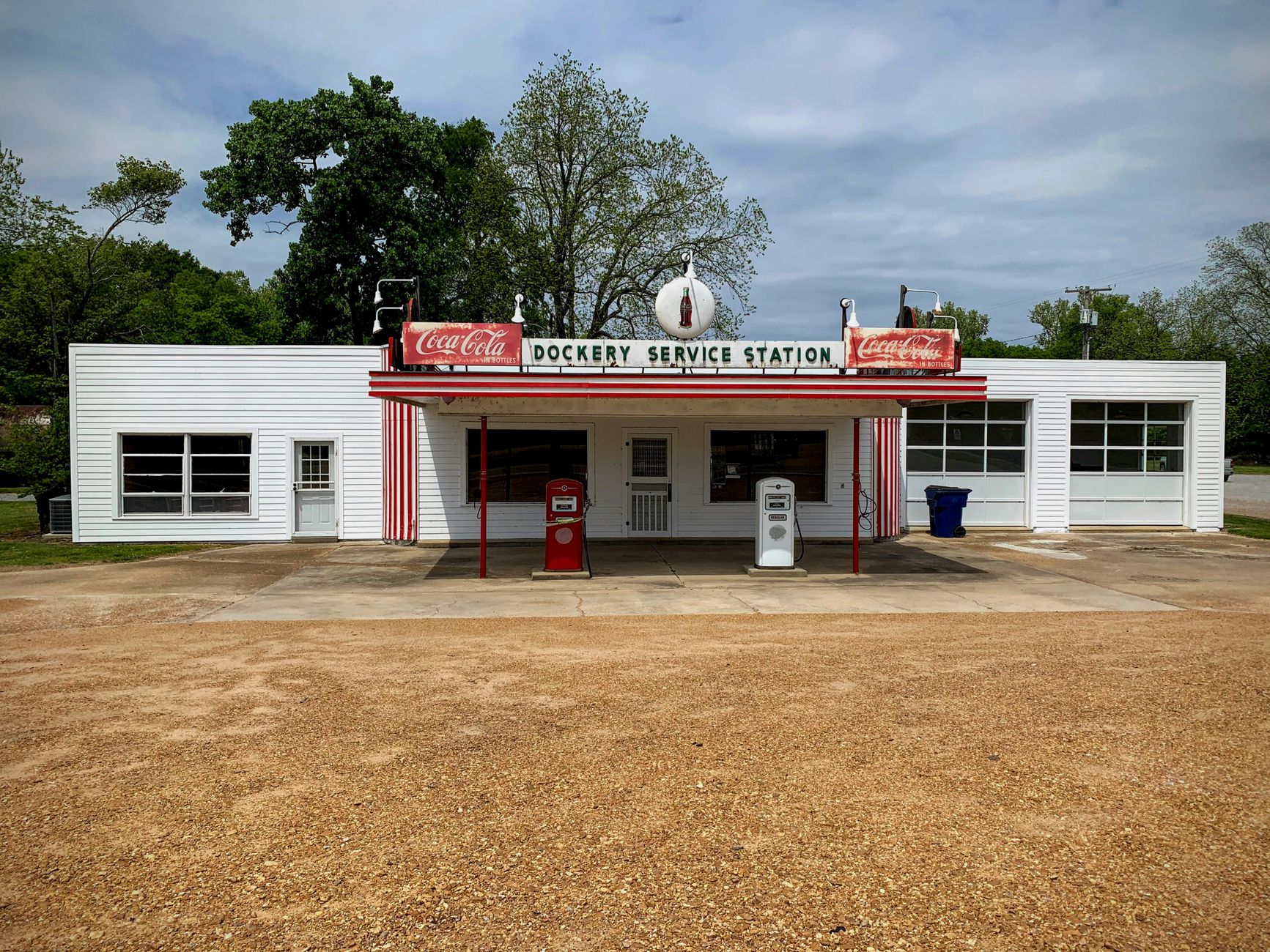 A vintage Dockery Service Station with classic gas pumps against a clear sky.