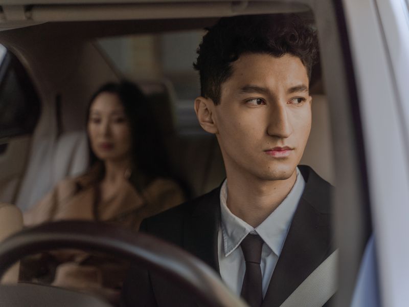 Professional driver in formal attire inside a corporate vehicle