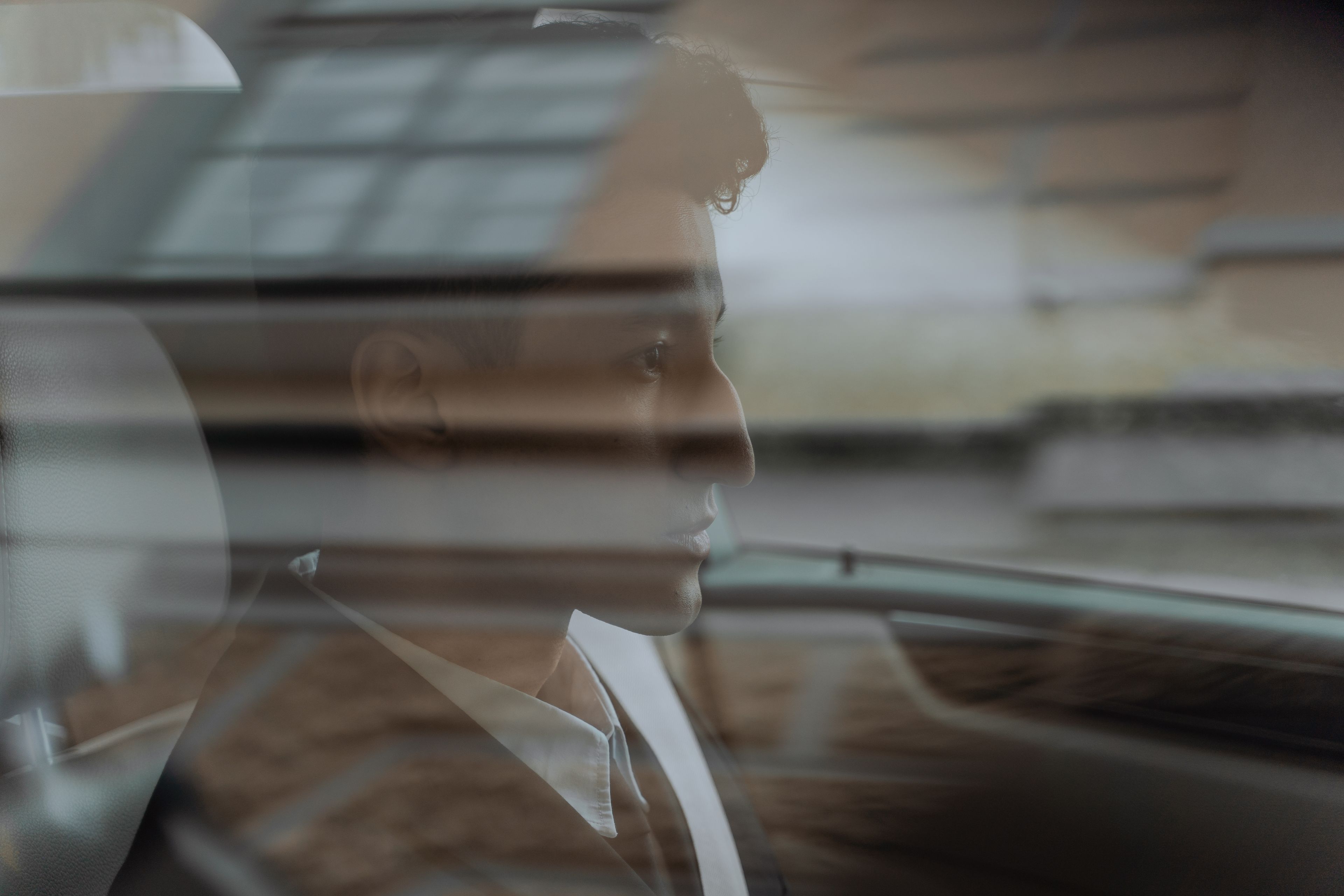 A professional chauffeur waiting beside a luxury car