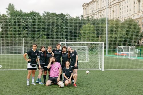 Free A group of women soccer players posing happily on a field, showcasing teamwork and diversity. Stock Photo