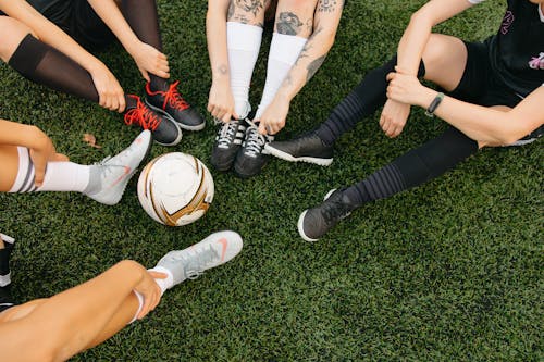 Legs Surrounding a Soccer Ball